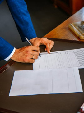 person writing on white form paper