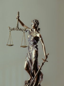 woman in gold dress holding sword figurine